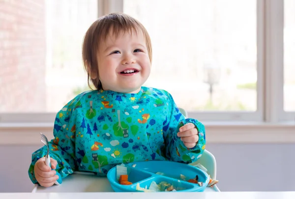 Happy toddler boy eating dinner — Stock Photo, Image