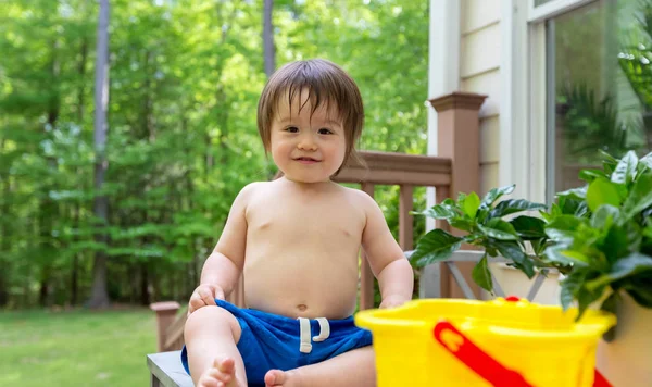 Jonge peuter jongen spelen met water — Stockfoto