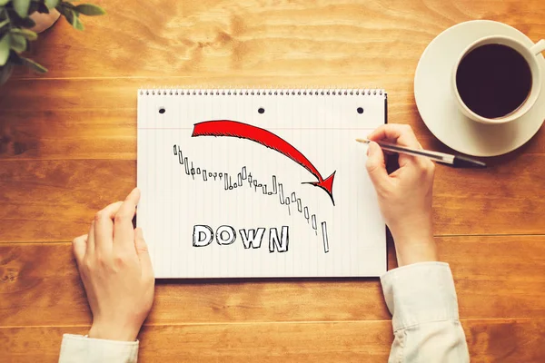 Nedåtgående trend diagram för marknaden med en person som innehar en penna — Stockfoto