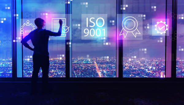 ISO 9001 with man by large windows at night