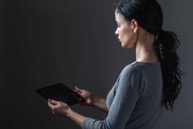 Tabletini kullanan genç bir kadın.