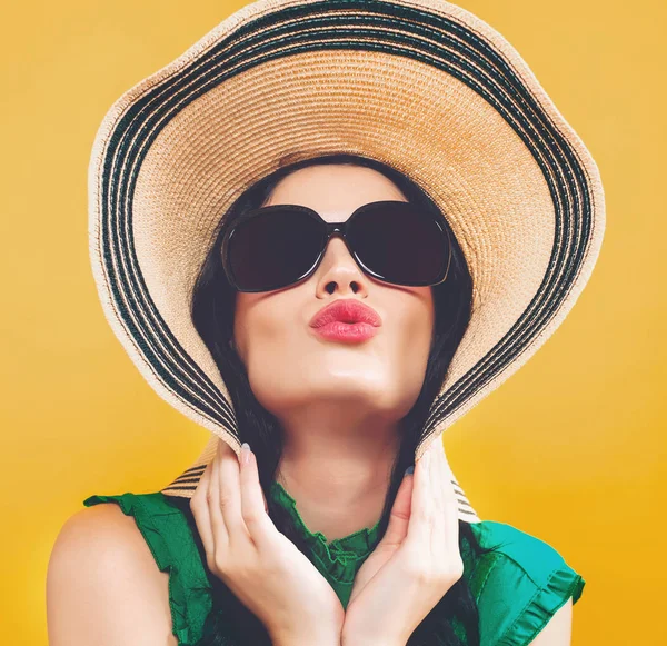 Jeune femme avec un chapeau et des lunettes de soleil — Photo