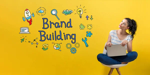 Brand building con donna utilizzando un computer portatile — Foto Stock