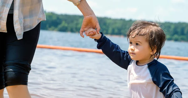 Niño pequeño cogido de la mano con su madre en un gran lago —  Fotos de Stock