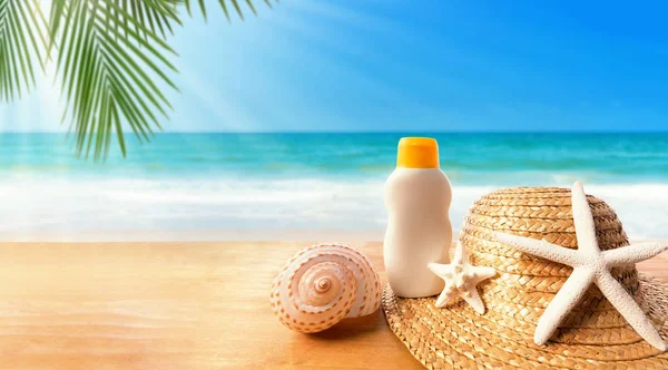 Crema solare con cappello di paglia su una spiaggia tropicale — Foto Stock