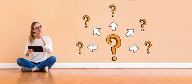 Büyük ve küçük soru işaretleri ile oklarla bir tabl kullanan kadın