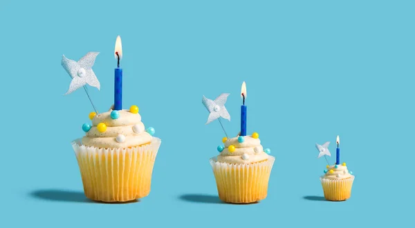 Grandes e pequenos cupcakes com velas acesas — Fotografia de Stock