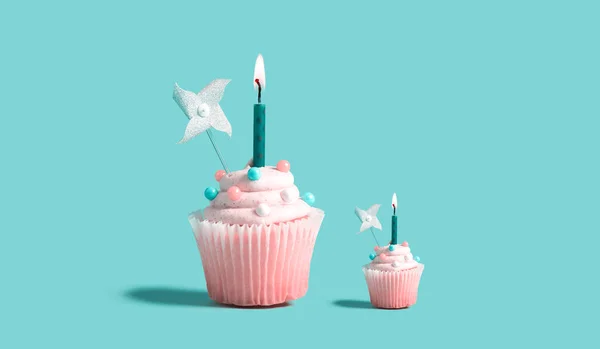 Grandes e pequenos cupcakes com velas acesas — Fotografia de Stock