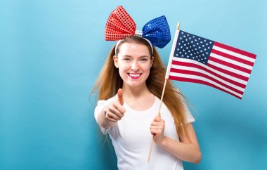 Bir Amerikan bayrağı tutan mutlu genç kadın