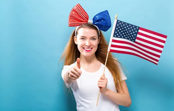 Ευτυχισμένη γυναίκα κρατώντας μια αμερικανική σημαία — Φωτογραφία Αρχείου