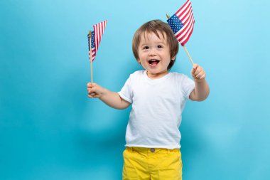Amerikan bayrakları sallayarak mutlu yürümeye başlayan çocuk