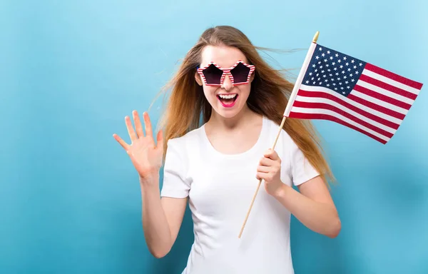 Happy young woman holding an American flag — Stock Photo, Image