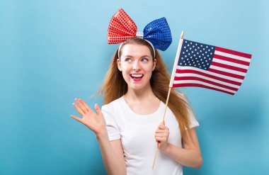 Bir Amerikan bayrağı tutan mutlu genç kadın