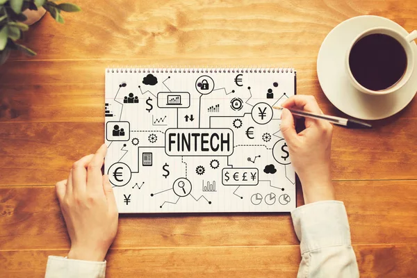 Fintech theme with a person writing in a notebook — Stock Photo, Image