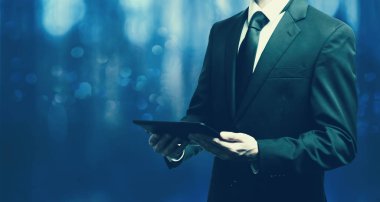 Elinde tablet bilgisayar tutan bir işadamı