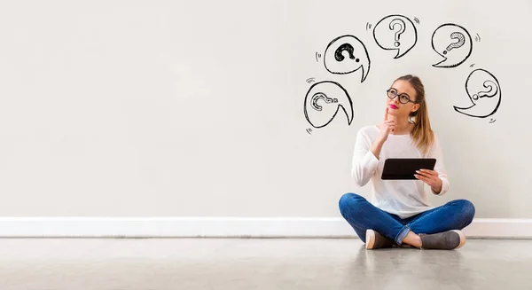 Vraagtekens met spraakballonnen met vrouw met een Tablet — Stockfoto