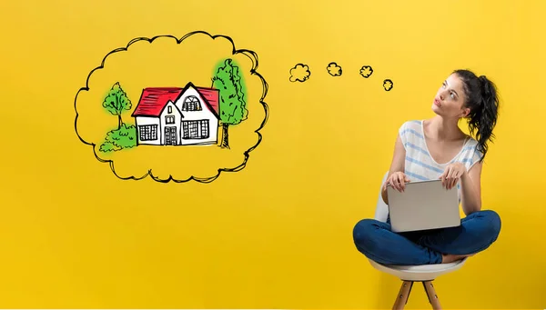 Dreaming of new home with woman using a laptop — Stock Photo, Image