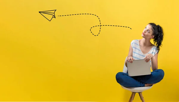 Papieren vliegtuig met vrouw met behulp van een laptop — Stockfoto