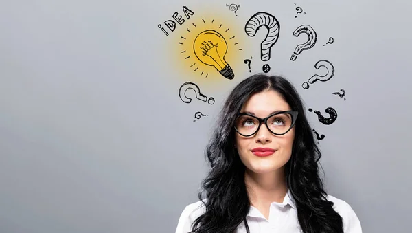 Idea light bulbs with question marks with young businesswoman — Stock Photo, Image