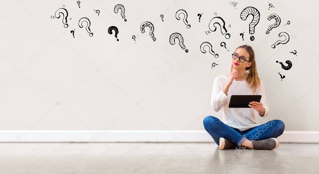 Question marks with woman using a tablet