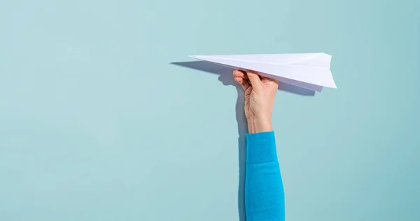 Persoon die een papieren vliegtuig vasthoudt — Stockfoto