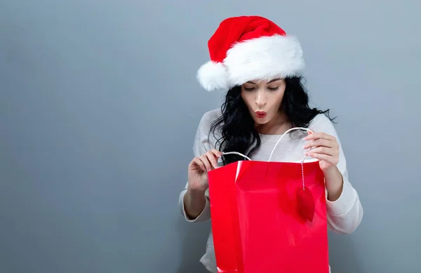 Joyeux jeune femme avec chapeau Santa tenant un sac à provisions — Photo