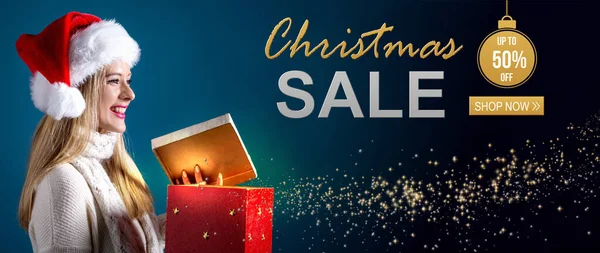 Christmas sale message with woman opening a gift box — Stock Photo, Image