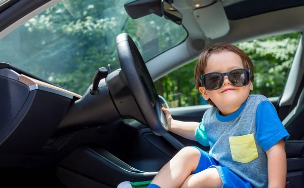 Egy kisgyerek, aki autóban játszik. — Stock Fotó