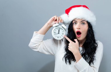 Bir saati yaklaşık 12 gösteren tutan genç kadın