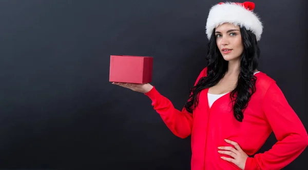 Giovane donna con cappello di Babbo Natale in possesso di una scatola regalo — Foto Stock