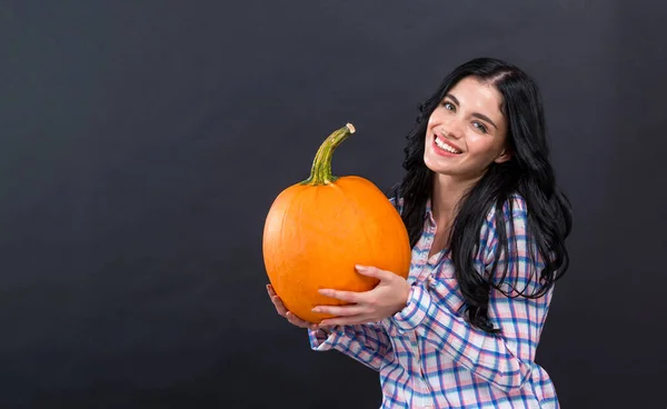 Jonge vrouw met een pompoen — Stockfoto