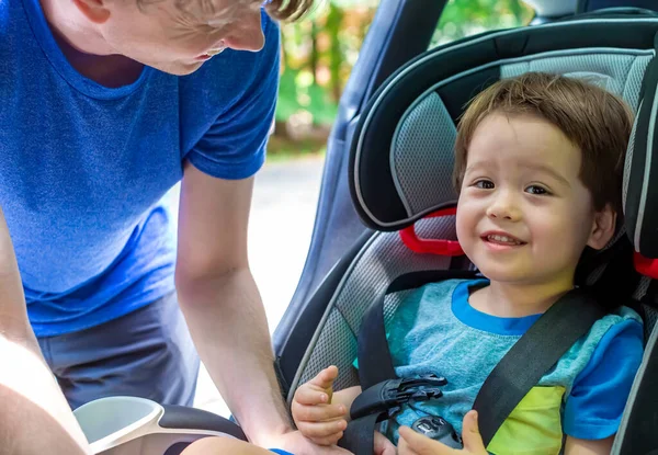 Criança menino fivela em seu assento de carro — Fotografia de Stock