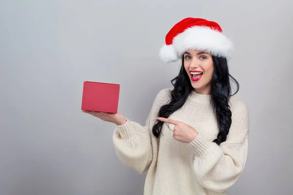 Mujer joven con sombrero de Santa sosteniendo una caja de regalo —  Fotos de Stock