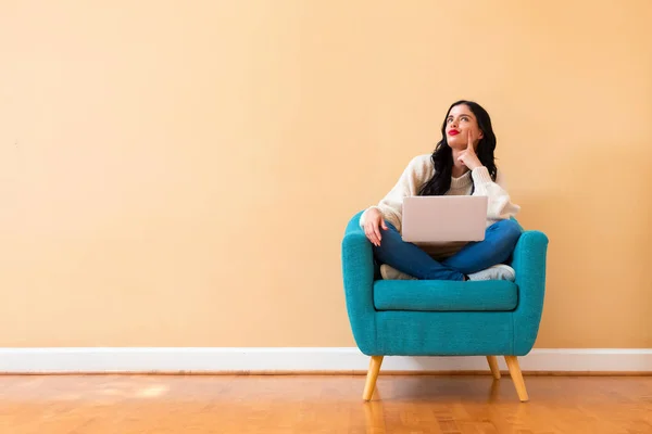 Giovane donna con un computer portatile in una posa premurosa — Foto Stock