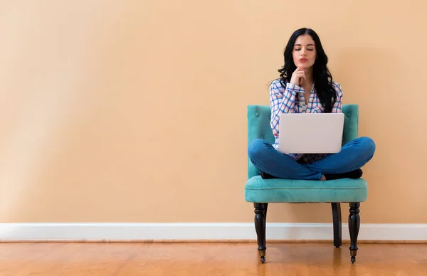 Junge Frau mit Laptop in nachdenklicher Pose — Stockfoto