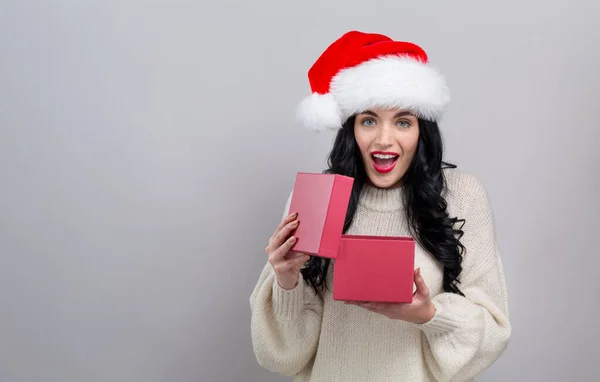 Ung kvinna öppnar en julklappslåda — Stockfoto