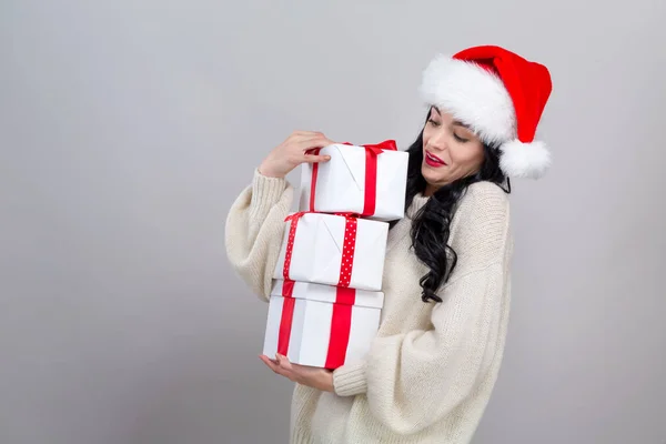 Jeune femme avec chapeau santa tenant des boîtes-cadeaux — Photo