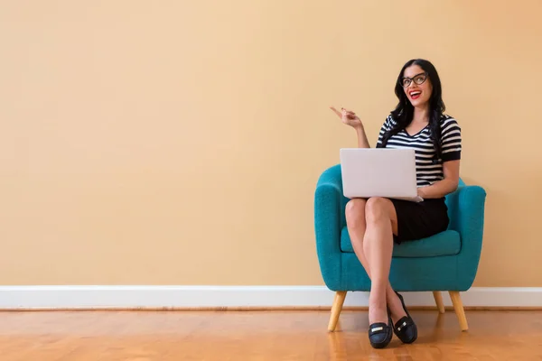 Jonge vrouw met een laptopcomputer iets te wijzen — Stockfoto