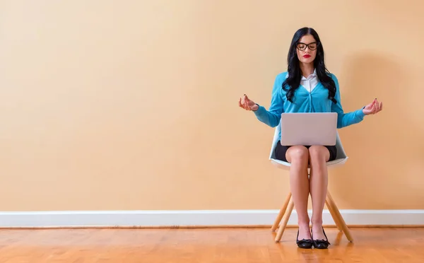 Giovane donna con computer portatile in posa di meditazione — Foto Stock