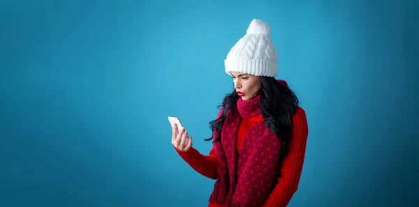 Jonge vrouw met kerst thema met behulp van haar telefoon — Stockfoto