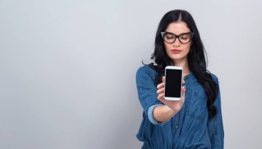 Dışarı bir telefon elinde tutan genç kadın