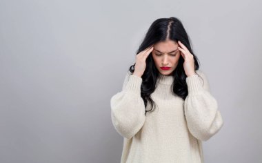 Baş ağrısı çeken genç bir kadın.