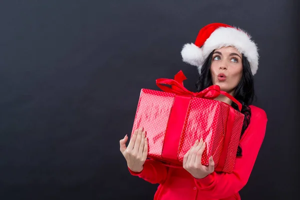 Giovane donna con cappello di Babbo Natale in possesso di una scatola regalo — Foto Stock