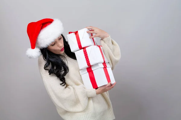 Giovane donna con cappello di Babbo Natale contenente scatole regalo — Foto Stock