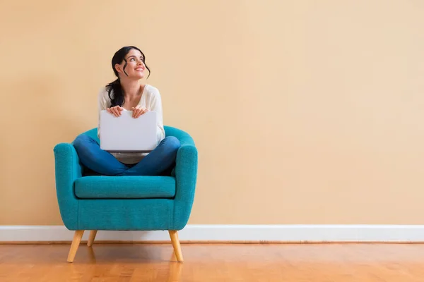 Giovane donna con un computer portatile in una posa premurosa — Foto Stock