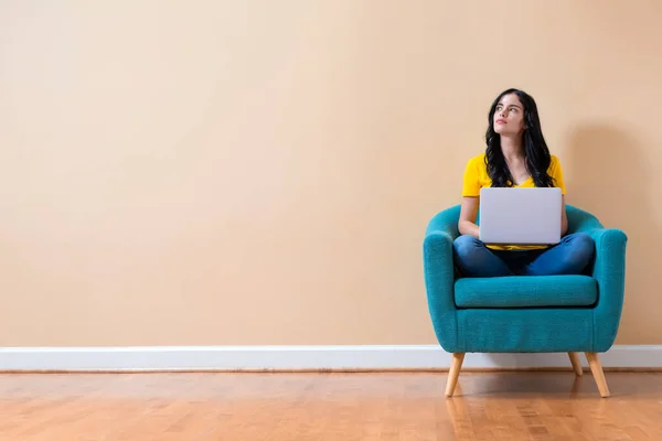 Junge Frau mit Laptop in nachdenklicher Pose — Stockfoto