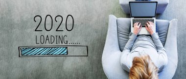 Yeni yıl 2020 'de dizüstü bilgisayar kullanan bir adamla yükleniyor