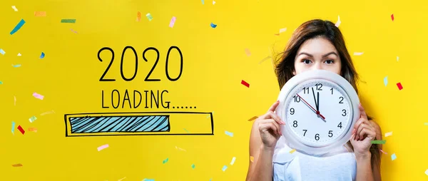 Loading new year 2020 with young woman holding a clock — Stock Photo, Image