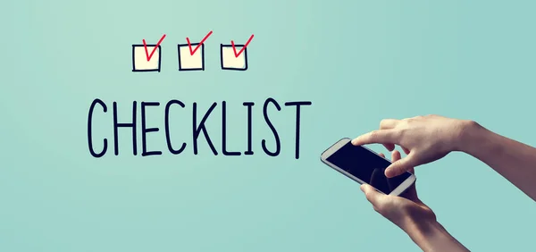 Checklist with person holding smartphone — Stock Photo, Image