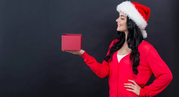 Jeune femme avec chapeau santa tenant une boîte cadeau — Photo